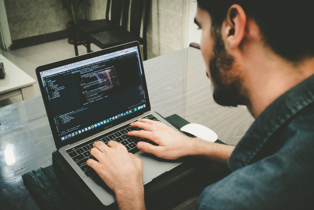 Man using laptop with computer coding on it