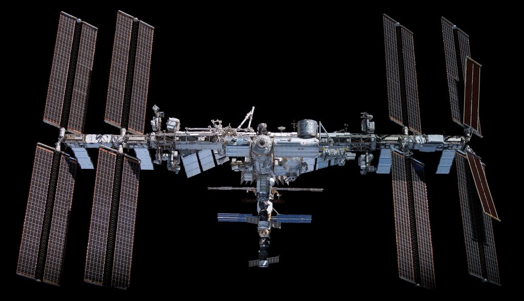 Closeup front angled view of the International Space Station surrounded by the dark of space