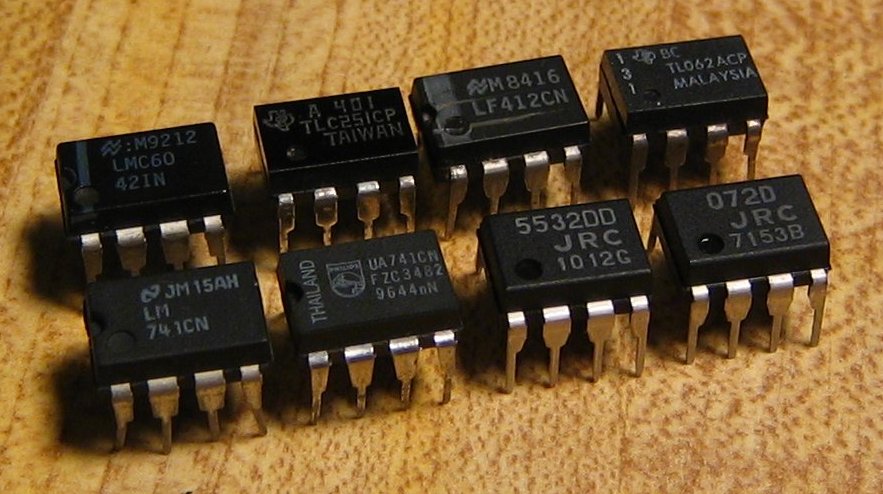 Picture of 8 black op-amps on a wooden surface