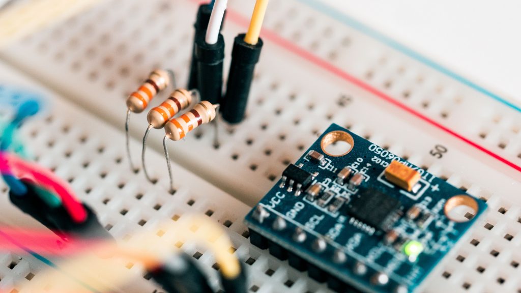 Closeup of beadboard with circuit board and resistor with color coded rings