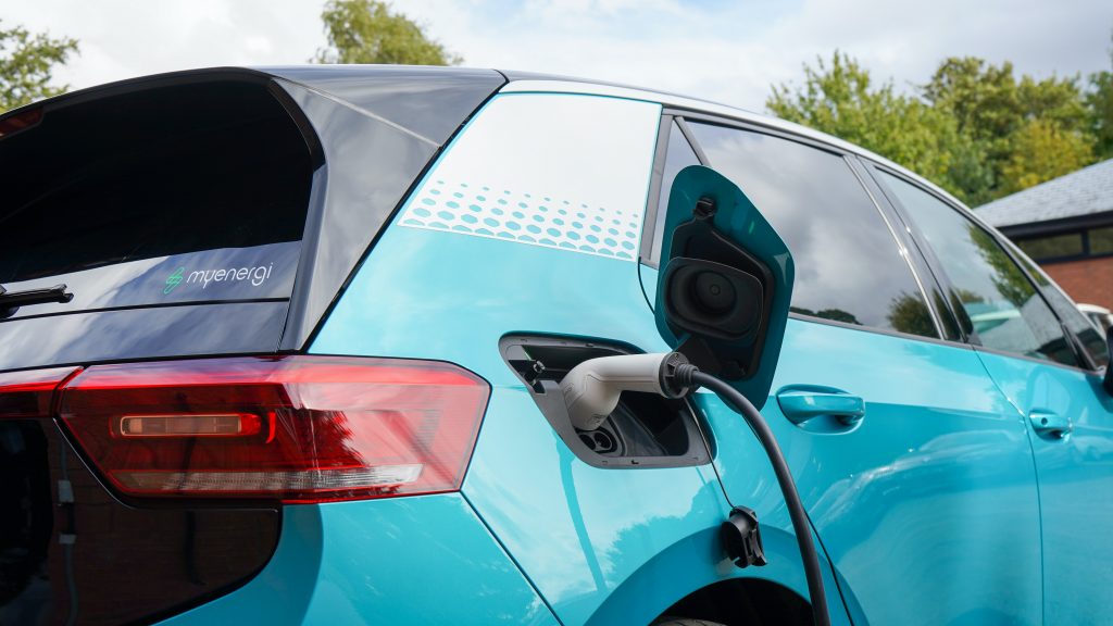 Closeup of charger plugged into a bright blue electric vehicle