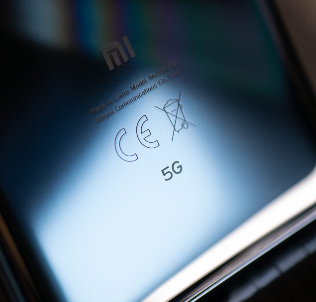 Closeup of the back of a black phone that says "5G"