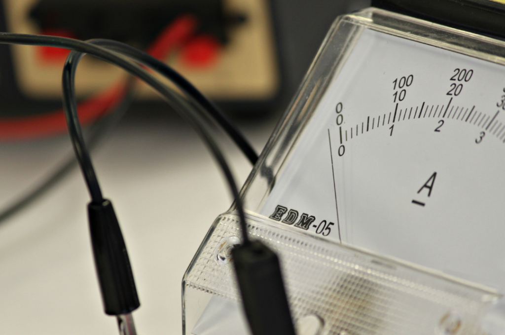 Closeup of an ammeter with two black leads 