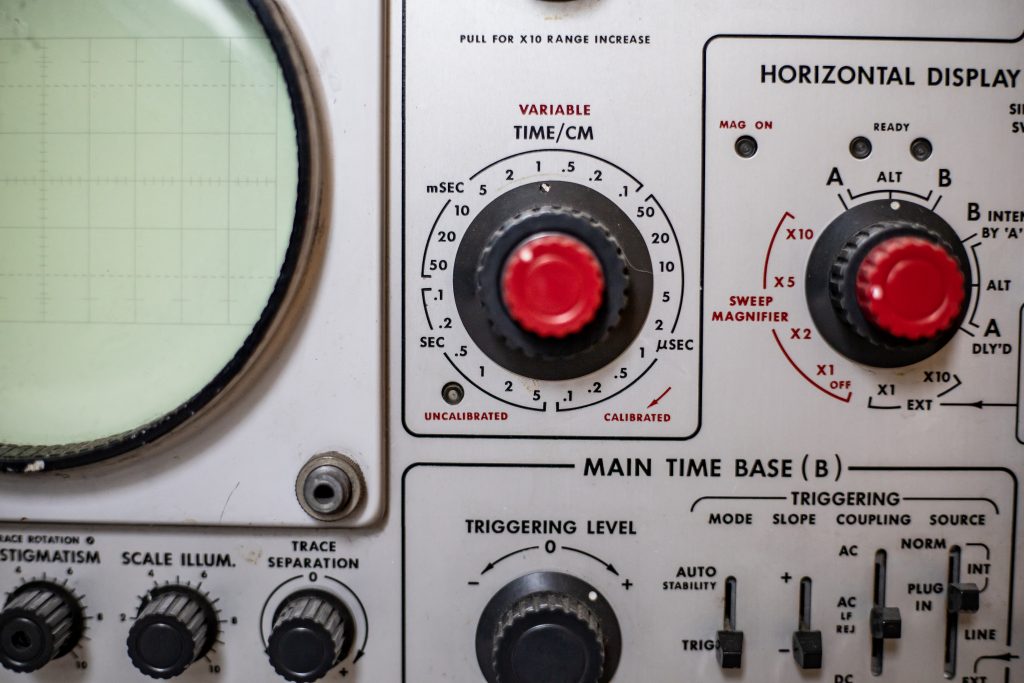 Closeup of analog oscilloscope dials and buttons