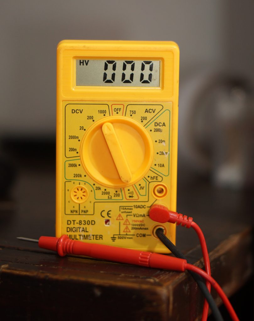 Closeup of yellow multimeter with digital display