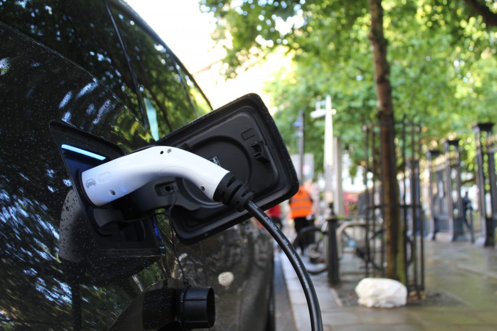 closeup of black electric car plugged in to charge