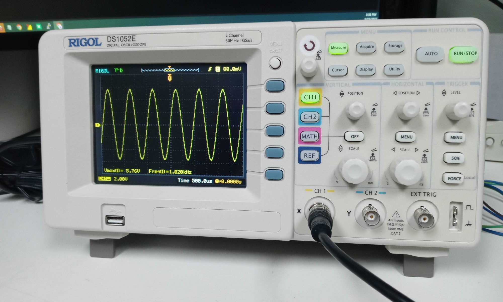 Closeup of Rigol oscilloscope displaying a sine wave