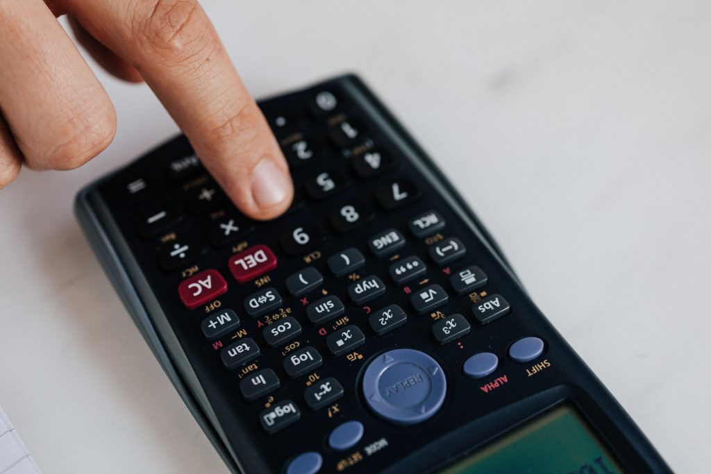 Closeup of a hand pressing the 6 button on a calculator