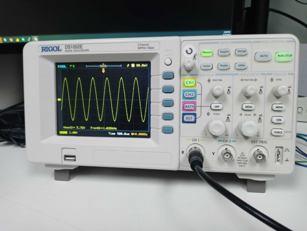 Closeup of RIGOL digital oscilloscope with sine wave on screen