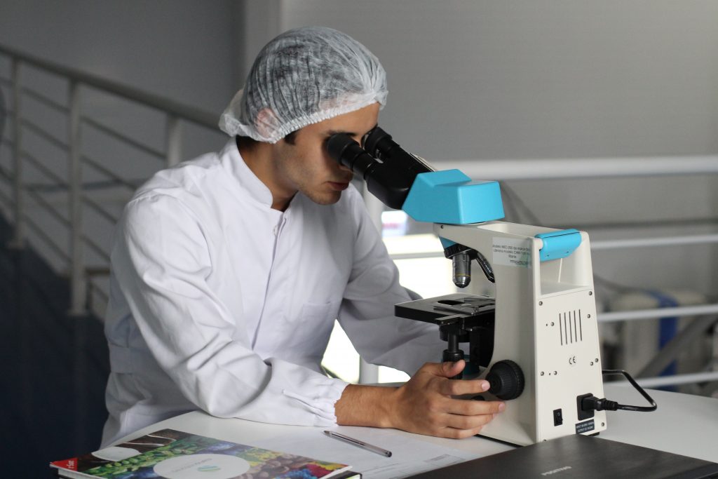 Scientist looking through microscope