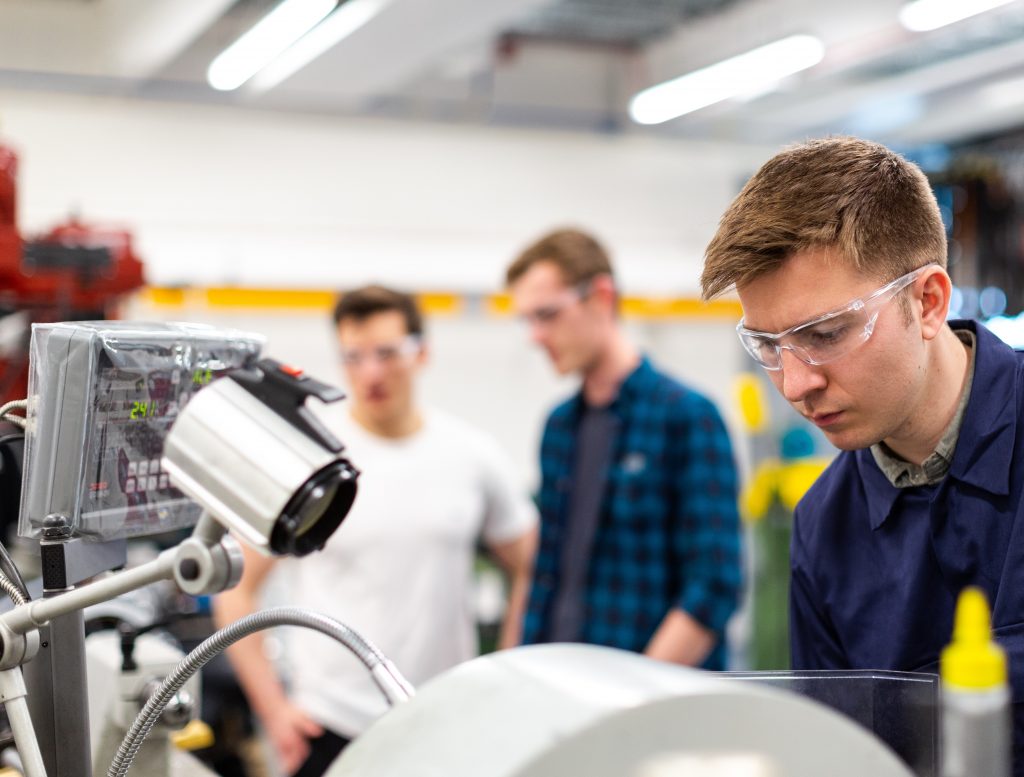 Closeup of 3 male engineers working in a lab