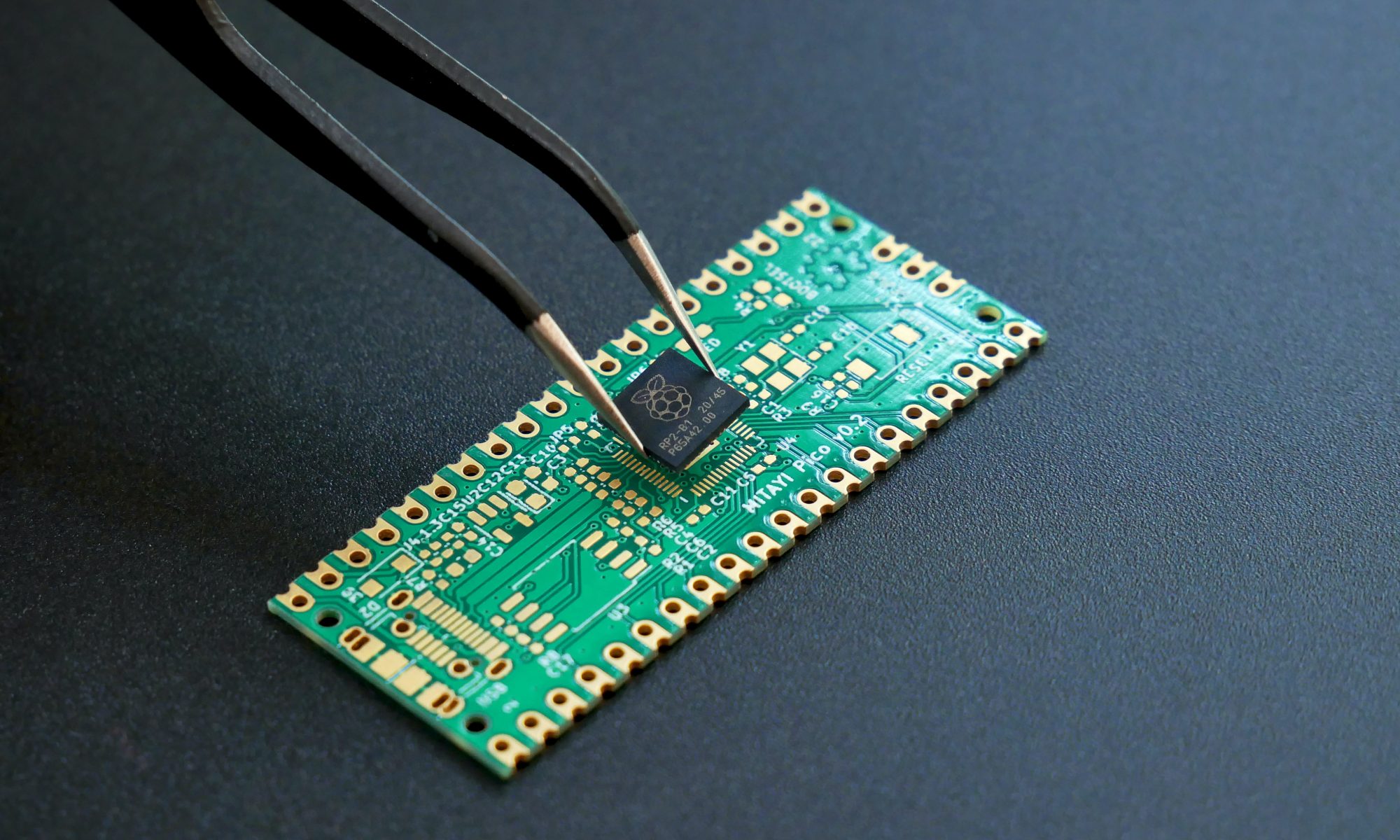Closeup of tweezers adding a chip onto a PCB