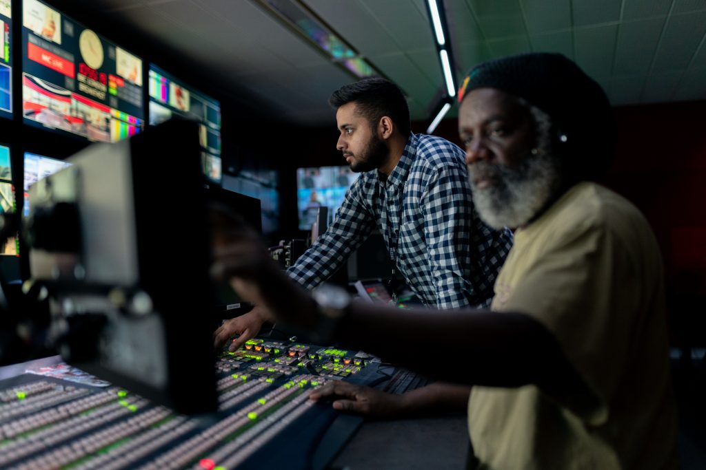 Closeup of broadcast engineers at work in studio