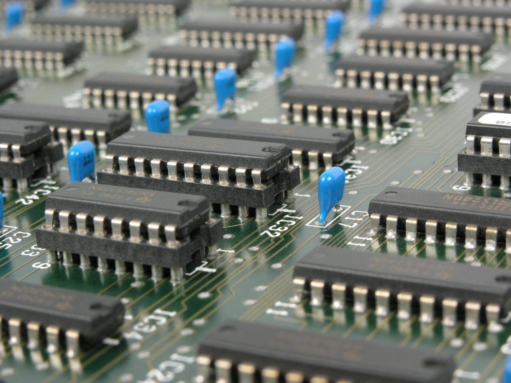 Black and Blue Electronic Tools on a Green Circuit Board