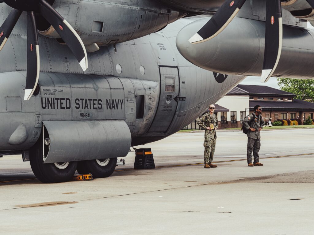 Closeup view of two Navy crew members beside a United States Navy plane