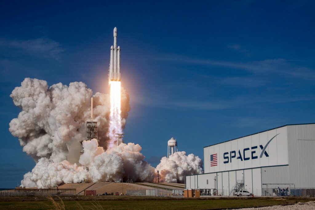 SpaceX Rocket launching from in front of the SpaceX building