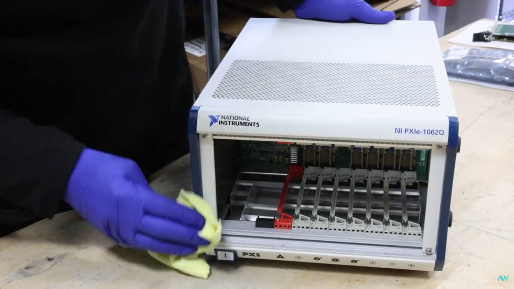 Technician wiping down a National Instruments Chassis with a microfiber cloth