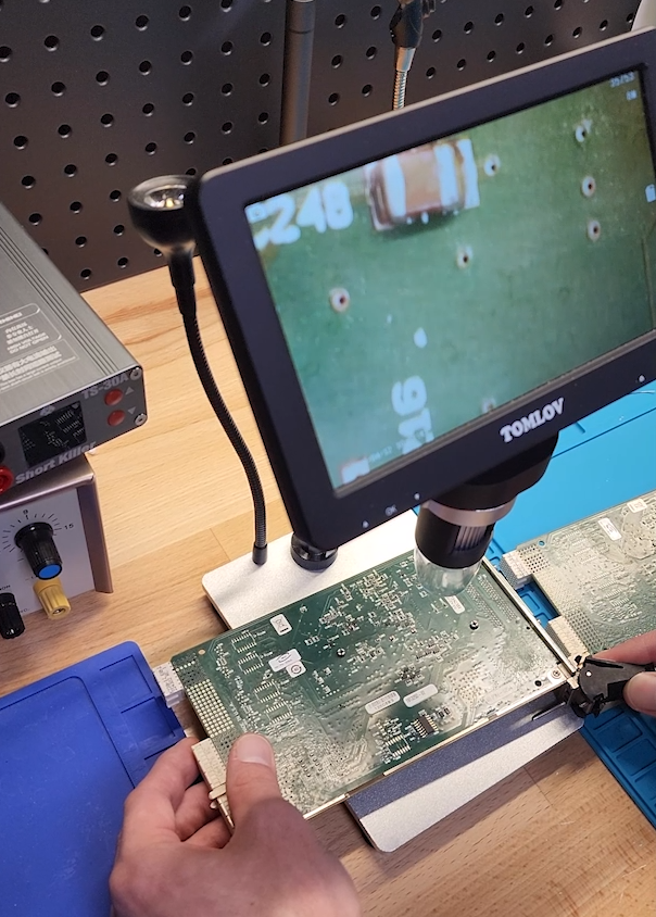 Apex Waves technician inspecting a PXI board for repair evaluation