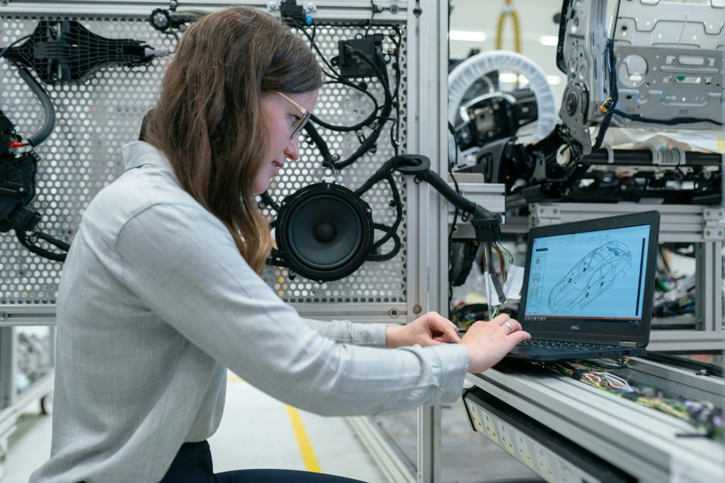 Female engineer uses laptop with Windows 10 in automotive lab